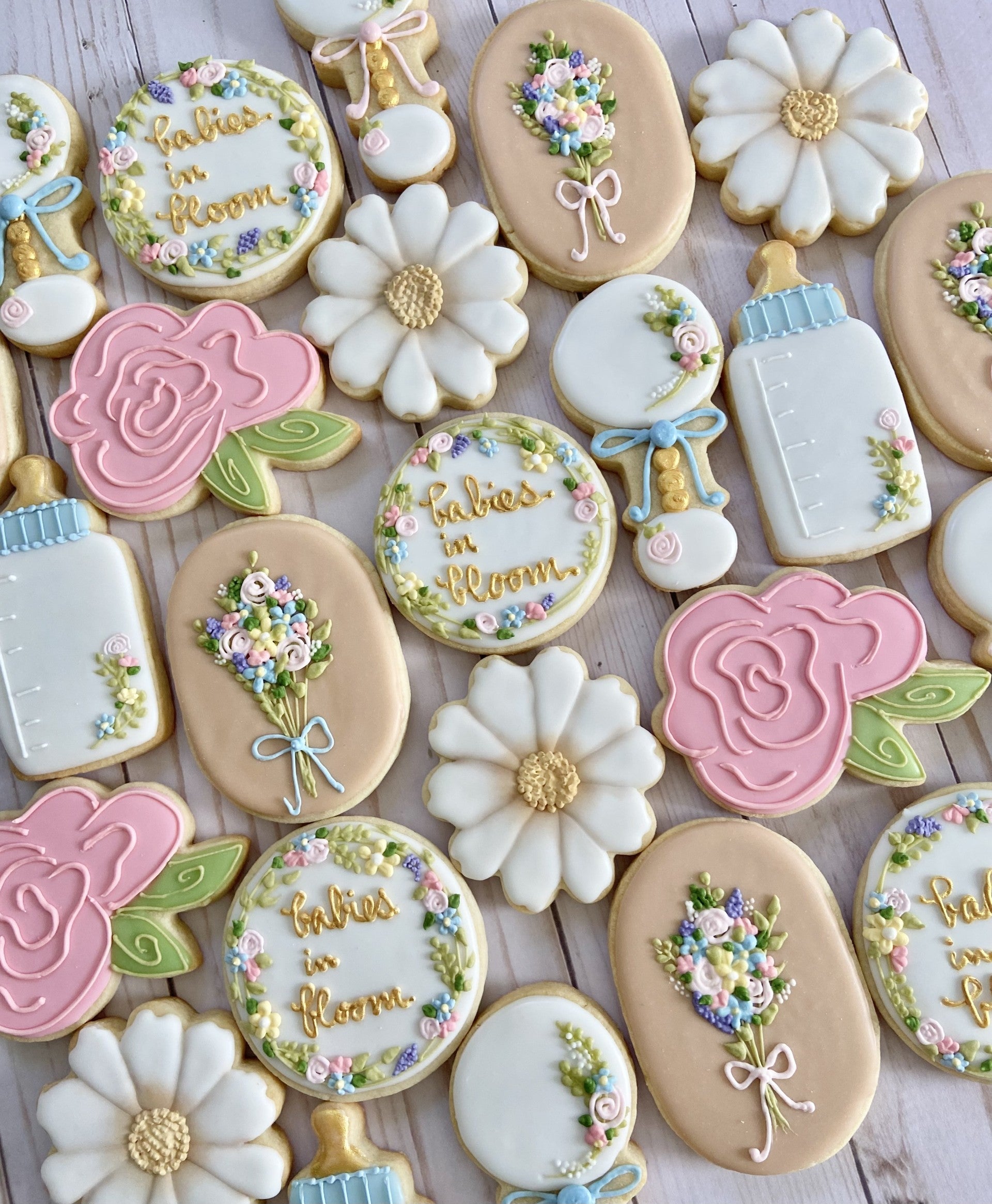 "Babies in Bloom" themed baby shower decorated cookies with pastel flowers.