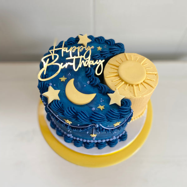 Sun and moon cake with vintage piping and gold Happy Birthday charm.