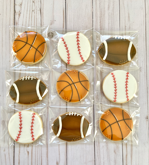 Cookies shaped like sports balls wrapped in clear packaging.